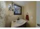 Stylish half bath featuring elegant lighting and a decorative mirror at 4020 E Laurel Ln, Phoenix, AZ 85028