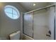 Bathroom features an oval window and a tub-shower with sliding glass doors for a bright and refreshing experience at 4020 E Laurel Ln, Phoenix, AZ 85028