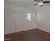 Neutral bedroom with hardwood floors, a ceiling fan, and a closet with white sliding doors at 4020 E Laurel Ln, Phoenix, AZ 85028