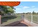 Outdoor patio with an orange umbrella, a white metal fence, and views of the golf course at 4020 E Laurel Ln, Phoenix, AZ 85028