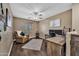 Comfortable home office featuring a ceiling fan, modern desk, hardwood floors, and ample lighting at 41369 W Parkhill Dr, Maricopa, AZ 85138