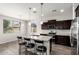Modern kitchen with granite counters, stainless steel appliances, dark cabinetry, and an island with seating at 4253 E Palo Verde St, Gilbert, AZ 85296