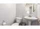 Cozy powder room features a pedestal sink, toilet, and modern fixtures at 4253 E Palo Verde St, Gilbert, AZ 85296