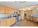 Well-lit kitchen featuring stainless steel appliances, wood cabinetry, and durable tile flooring at 4332 W Monte Cristo W Ave, Glendale, AZ 85306