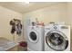 Functional laundry room with white washer and dryer, plus storage and door at 4332 W Monte Cristo W Ave, Glendale, AZ 85306