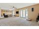 Large living room featuring tan carpet, white french doors, and a ceiling fan at 4332 W Monte Cristo W Ave, Glendale, AZ 85306