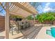 Comfortable patio seating under a shaded pergola near a built-in grill and pool area at 4332 W Monte Cristo W Ave, Glendale, AZ 85306