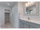 Well-lit bathroom with gray cabinets, and a linen closet with towels at 4440 E Campbell Ave, Phoenix, AZ 85018