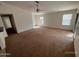 Spacious living room with carpet flooring, a ceiling fan, and windows at 46037 W Starlight Dr, Maricopa, AZ 85139