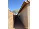 Narrow side yard with gravel, block wall, and a glimpse of a distant tree at 46037 W Starlight Dr, Maricopa, AZ 85139