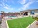 The backyard features a pool, artificial turf, desert landscaping, and a covered patio at 5581 N 206Th Ave, Buckeye, AZ 85396