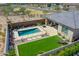 Aerial view of a modern backyard pool with surrounding patio, lush artificial turf, and desert landscaping at 5581 N 206Th Ave, Buckeye, AZ 85396