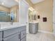Elegant bathroom with double sinks, quartz countertops, gray cabinetry, and a walk-in shower at 5581 N 206Th Ave, Buckeye, AZ 85396