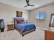 Cozy bedroom featuring rustic wood furniture, a ceiling fan, and a bright window at 5581 N 206Th Ave, Buckeye, AZ 85396