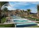Beautiful community pool area with mountain views, palm trees, lounge chairs, and umbrellas at 5581 N 206Th Ave, Buckeye, AZ 85396