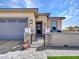 Inviting front entrance with stone pillars, pavers, wrought iron gate, and covered porch at 5581 N 206Th Ave, Buckeye, AZ 85396