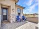 Cozy front porch featuring Adirondack chairs, a small table, and a charming desert view at 5581 N 206Th Ave, Buckeye, AZ 85396