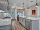 The bright kitchen features stainless appliances, gray cabinets, white countertops, and pendant lighting at 5581 N 206Th Ave, Buckeye, AZ 85396