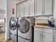 Modern laundry room features grey cabinets, granite countertops, stainless steel washer and dryer at 5581 N 206Th Ave, Buckeye, AZ 85396