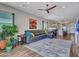 A spacious living room with a leather sectional, area rug, ceiling fan, and access to the kitchen at 5581 N 206Th Ave, Buckeye, AZ 85396