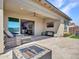 This outdoor patio features a fire pit, desert landscaping, and comfortable patio furniture at 5581 N 206Th Ave, Buckeye, AZ 85396