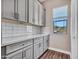 The butler's pantry boasts gray cabinets, white countertops, subway tile, and a window at 5581 N 206Th Ave, Buckeye, AZ 85396
