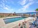 Stunning backyard pool featuring desert landscaping, a baja step, and a decorative privacy fence at 5581 N 206Th Ave, Buckeye, AZ 85396