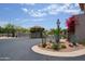 Elegant gated community entrance with desert landscaping, mature plants, and a charming guard house at 6144 S Fairway Pl, Gold Canyon, AZ 85118