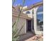 Front entrance featuring large windows, desert landscaping, and a secure black metal security gate at 6144 S Fairway Pl, Gold Canyon, AZ 85118