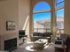 Inviting living room with soaring windows, a gray sofa, and a modern fireplace for relaxation at 6144 S Fairway Pl, Gold Canyon, AZ 85118