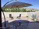 Outdoor brick patio featuring shade umbrella, desert landscape, and comfortable seating arrangement at 6144 S Fairway Pl, Gold Canyon, AZ 85118