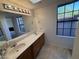 Bright bathroom with a double vanity, large mirror, and a window for natural light at 6945 E Cochise Rd # 108, Paradise Valley, AZ 85253