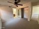 Bedroom with neutral carpet, ceiling fan, mirrored closet doors, and views into the bathroom and hallway at 6945 E Cochise Rd # 108, Paradise Valley, AZ 85253