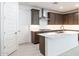 Modern kitchen with white countertops, dark wood cabinets, and stainless steel appliances at 7433 W Buckhorn Trl, Peoria, AZ 85383