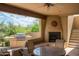 Covered patio with an outdoor kitchen, fireplace, and comfortable seating at 8400 E Dixileta Dr # 153, Scottsdale, AZ 85266