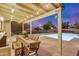 Charming backyard with covered patio, dining area, sparkling pool, and landscaped yard at twilight at 863 W Kiva Ave, Mesa, AZ 85210