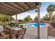 Inviting covered patio overlooks a backyard with a sparkling pool and lush landscaping, great for entertaining at 863 W Kiva Ave, Mesa, AZ 85210