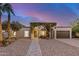 Inviting single-story home with arched entryway covered in lush greenery and a well-maintained landscape at 863 W Kiva Ave, Mesa, AZ 85210