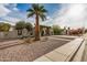 A desert landscaped home featuring mature trees, with a vine-covered archway and a concrete driveway at 863 W Kiva Ave, Mesa, AZ 85210