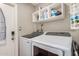 Laundry room with washer, dryer, storage shelves, and ironing board, equipped for convenience at 863 W Kiva Ave, Mesa, AZ 85210