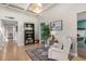 Cozy living room area with art, shelving, comfortable chair, and natural light shining through the windows at 863 W Kiva Ave, Mesa, AZ 85210