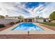 Backyard pool with a concrete deck, privacy fence, grassy area, and an outdoor kitchen at 863 W Kiva Ave, Mesa, AZ 85210