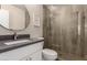 Modern bathroom featuring a glass shower, pebble tile floor, framed mirror, and gray countertop at 8637 E Weldon Ave, Scottsdale, AZ 85251