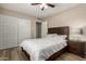 Relaxing bedroom with a spacious closet, ceiling fan, comfortable bed, and modern wood-look floors at 8637 E Weldon Ave, Scottsdale, AZ 85251