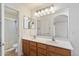 Bright bathroom with a double sink vanity, large mirror and a glass enclosed shower at 8708 S 50Th Ln, Laveen, AZ 85339