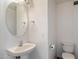 Powder room including a pedestal sink, toilet and a round mirror at 8708 S 50Th Ln, Laveen, AZ 85339