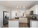 Modern kitchen with laminate floors, stainless steel appliances, and white cabinets at 8708 S 50Th Ln, Laveen, AZ 85339