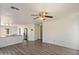 Open living room with laminate floors, ceiling fan, and adjacent kitchen at 8708 S 50Th Ln, Laveen, AZ 85339