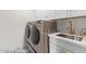 Laundry room with modern machines, patterned tile floor, white cabinets, and sink at 8989 N Gainey Center Dr # 231, Scottsdale, AZ 85258