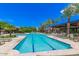 Community lap pool surrounded by palm trees and lounge chairs with clubhouse at 8989 N Gainey Center Dr # 231, Scottsdale, AZ 85258